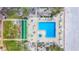 Aerial view of community pool and shuffleboard area surrounded by manicured landscaping and beach at 18304 Gulf Blvd # 217, Redington Shores, FL 33708