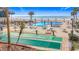 Community pool with shuffleboard, lounge chairs and beach access on a sunny day at 18304 Gulf Blvd # 217, Redington Shores, FL 33708
