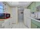 Well-maintained kitchen with ample storage, white tile floors, and neutral color scheme at 19029 Us Highway 19 N # 8-15, Clearwater, FL 33764