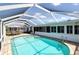 An aerial view of a kidney-shaped pool and a sitting area under an enclosed screen at 2821 Coral Way, Punta Gorda, FL 33950