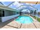 A kidney-shaped pool is surrounded by an enclosed screen with a seating area at 2821 Coral Way, Punta Gorda, FL 33950