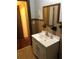 Compact bathroom with a white sink vanity, framed mirror, and tiled walls showcasing retro design elements at 3201 N 15Th St, Tampa, FL 33605