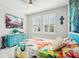 Bright bedroom with a colorful butterfly themed comforter, blue dresser and modern ceiling fan at 32231 Conchshell Sail St, Wesley Chapel, FL 33545