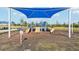 A sunny playground offering multiple slides and play areas, covered by a blue sunshade, set in a landscaped community at 32231 Conchshell Sail St, Wesley Chapel, FL 33545