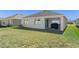 Back view of the house featuring a covered patio and a spacious backyard at 35583 Burma Reed Dr, Zephyrhills, FL 33541