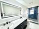 Bright bathroom featuring double sink vanity with blue-tiled shower and glass door at 3735 69Th N Way, St Petersburg, FL 33710