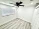 Bright bedroom features light wood floors, neutral walls, ceiling fan, and closet at 3735 69Th N Way, St Petersburg, FL 33710