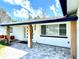 Inviting front porch with stone pavers, natural wood columns, and an updated front door and sidelight at 3735 69Th N Way, St Petersburg, FL 33710