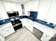 Bright kitchen featuring stainless steel appliances, white cabinetry, blue tile backsplash, and quartz countertops at 3735 69Th N Way, St Petersburg, FL 33710