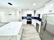 Updated kitchen with a waterfall island, stainless steel appliances, white cabinetry, and stylish lighting at 3735 69Th N Way, St Petersburg, FL 33710