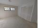 Neutral bedroom featuring wall trim, window, and a closet with folding doors at 375 Woods Landing Trl, Oldsmar, FL 34677