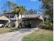 Inviting two-story home with carport, featuring neutral paint, lush landscaping, and a concrete driveway at 375 Woods Landing Trl, Oldsmar, FL 34677