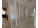 Hallway featuring paneled mirrors, tile flooring and an entry door at 375 Woods Landing Trl, Oldsmar, FL 34677
