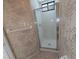 Bathroom shower featuring glass doors, neutral wallpaper, and tile flooring at 375 Woods Landing Trl, Oldsmar, FL 34677
