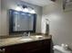 Bathroom featuring granite countertop, framed mirror, decorative lights, and cherry-finished cabinets at 5434 Saddlebrook Way # 3, Wesley Chapel, FL 33543