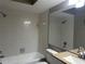Bright bathroom with a shower and bath combination, featuring tiled walls and a large mirror at 5434 Saddlebrook Way # 3, Wesley Chapel, FL 33543