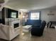 Cozy living room with a fireplace, dark reclining sofas, and lots of natural light at 5434 Saddlebrook Way # 3, Wesley Chapel, FL 33543
