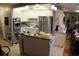 A kitchen features stainless steel appliances, white cabinets with blue trim, and an island with counter seating at 6000 20Th N St # 141, St Petersburg, FL 33714