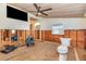 Bathroom featuring partial wood paneling, a ceiling fan, and a toilet at 607 Manatee Ave, Ellenton, FL 34222
