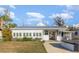 Exterior view of the home with well-maintained landscaping, driveway, and an enclosed spa area at 607 Manatee Ave, Ellenton, FL 34222