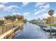 Scenic waterfront view featuring a canal with docks and lush green landscaping under a bright blue sky at 607 Manatee Ave, Ellenton, FL 34222