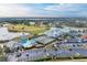 Aerial view showcasing the clubhouse, pool, tennis courts, golf course, and parking area at 6325 Stone River Rd, Bradenton, FL 34203