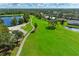 Picturesque aerial view of a lush golf course with a winding path, lake, and surrounding homes at 6325 Stone River Rd, Bradenton, FL 34203