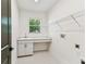 Bright laundry room with modern gray tile, sink with white countertop and storage, and wire shelving at 713 W West St, Tampa, FL 33603