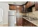 Compact kitchenette featuring granite countertops, stainless steel appliances, and dark wood cabinetry at 7701 Jackson Spring Rd, Tampa, FL 33615