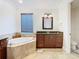 Elegant bathroom featuring soaking tub, granite counters, and custom vanity for a luxurious feel at 8264 Dunham Station Dr, Tampa, FL 33647