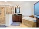 Modern bathroom featuring a separate shower, soaking tub, and granite vanity at 8264 Dunham Station Dr, Tampa, FL 33647