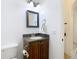 Bathroom features a vanity with a dark countertop, square mirror, and modern lighting at 8264 Dunham Station Dr, Tampa, FL 33647