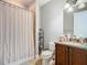 Cozy bathroom featuring a shower with curtain, toilet, and vanity with cabinet storage at 8264 Dunham Station Dr, Tampa, FL 33647