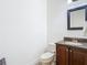 Small half bathroom with a dark wooden vanity and mirror at 8264 Dunham Station Dr, Tampa, FL 33647