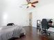 Inviting bedroom featuring hardwood floors, a bed with striped bedding, and a ceiling fan at 8264 Dunham Station Dr, Tampa, FL 33647