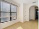 Bedroom features neutral carpet, a large window, and an arched entranceway at 8264 Dunham Station Dr, Tampa, FL 33647