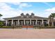 Community clubhouse featuring a covered porch with multiple columns, dormer windows, and brick landscaping at 8264 Dunham Station Dr, Tampa, FL 33647