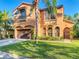 Charming two-story stucco home with a two-car garage, balcony, arched windows, and well-manicured lawn at 8264 Dunham Station Dr, Tampa, FL 33647
