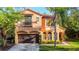 Two-story home with a brown garage door, a red tile roof, arched windows, and manicured landscaping at 8264 Dunham Station Dr, Tampa, FL 33647