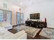 Bright living room with tall ceilings, hardwood floors, white sofa, large windows, and access to the patio at 8264 Dunham Station Dr, Tampa, FL 33647
