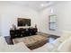 Open living space with hardwood floors, white sofa, large TV, and modern console table at 8264 Dunham Station Dr, Tampa, FL 33647