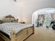 Main bedroom boasts neutral carpet, ornate bed frame, and an archway to an adjacent room at 8264 Dunham Station Dr, Tampa, FL 33647