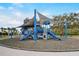 Community playground featuring a large, shaded play structure with multiple slides and climbing areas, surrounded by a cushioned surface at 8264 Dunham Station Dr, Tampa, FL 33647