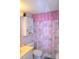 Bathroom featuring shower with floral print curtain and cabinet for bathroom essentials at 960 Virginia St # 205, Dunedin, FL 34698