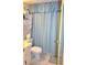 Bathroom featuring shower with blue curtain and cabinet for bathroom essentials at 960 Virginia St # 205, Dunedin, FL 34698