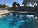 Refreshing community pool with ample lounge chairs, tables, and shade for residents to enjoy at 960 Virginia St # 205, Dunedin, FL 34698