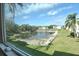 Expansive view of the community pond showcasing the building exteriors and beautiful natural landscaping at 960 Virginia St # 205, Dunedin, FL 34698