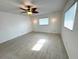Bright bedroom featuring tile floors, ceiling fan, and ample natural light from large windows at 10063 40Th N St # 3, Pinellas Park, FL 33782