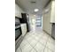 Open kitchen with stainless steel appliances, tiled floors, and white cabinets at 10063 40Th N St # 3, Pinellas Park, FL 33782