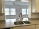 Close-up of sink with view to bright, window-filled living room at 10063 40Th N St # 3, Pinellas Park, FL 33782